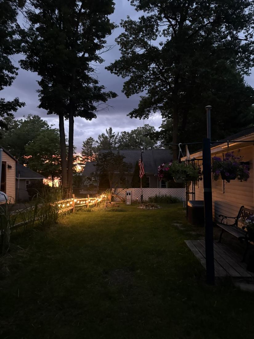 the back yard at dusk with the lights on